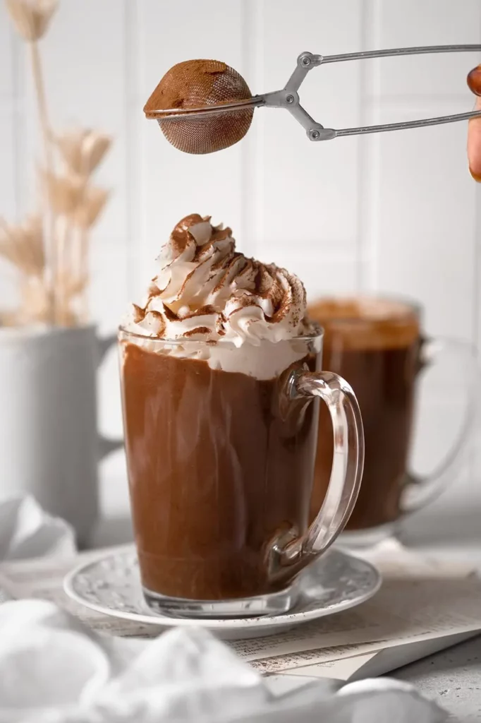 Chocolat chaud vegan avec cacao saupoudré sur la chantilly