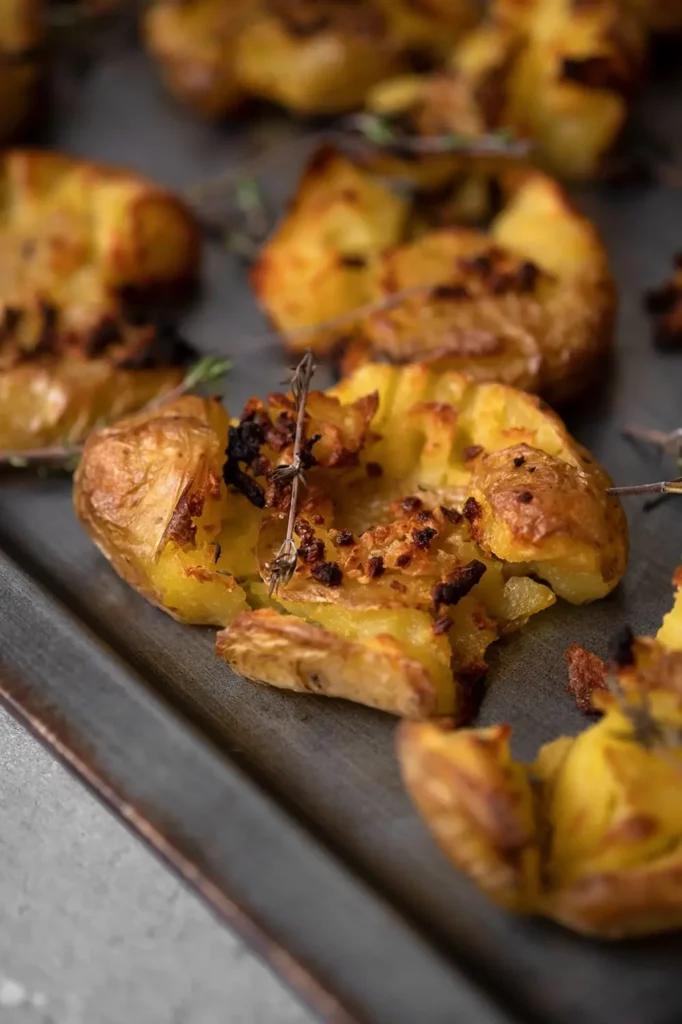 Pommes de terre écrasées au four dorées avec herbes et gros sel