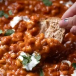 Ragoût de haricots blancs à la tomate servi avec une touche crémeuse
